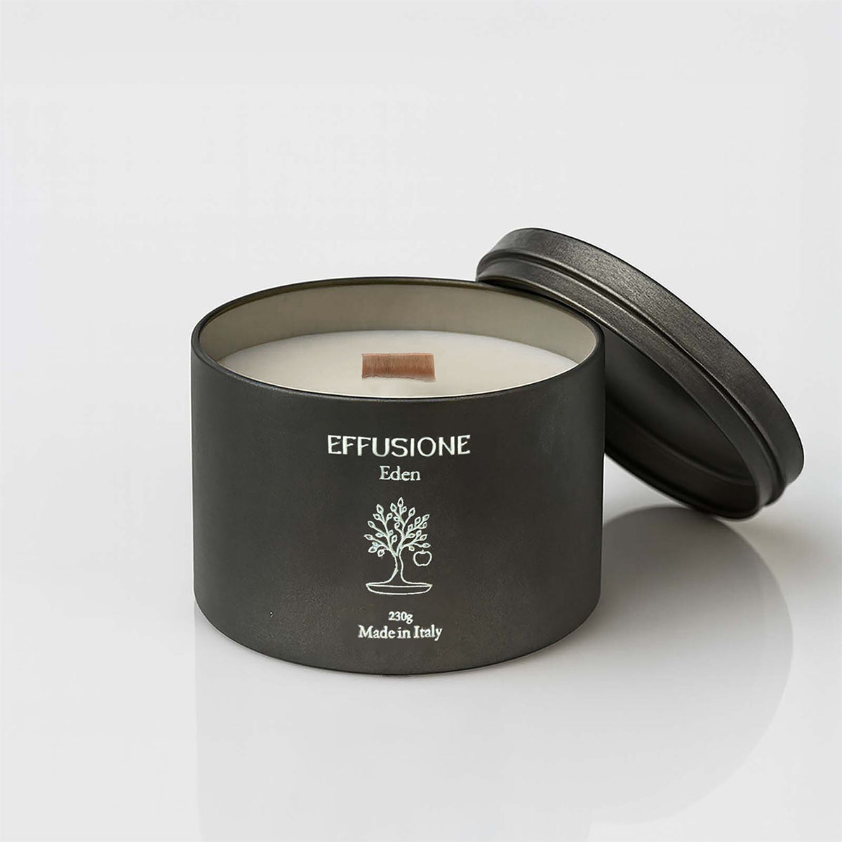 Candela profumata Echo Eden di Effusione da 230 g, cera color avorio e stoppino in legno, con coperchio nero appoggiato sul retro