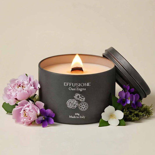 Candela profumata Effusione Oasi Zegna accesa, con note floreali e agrumate.