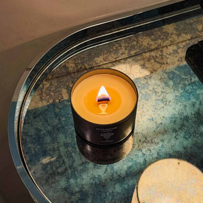 Candela profumata Echo Effusione fragranza Uva Rara accesa su tavolo di design.