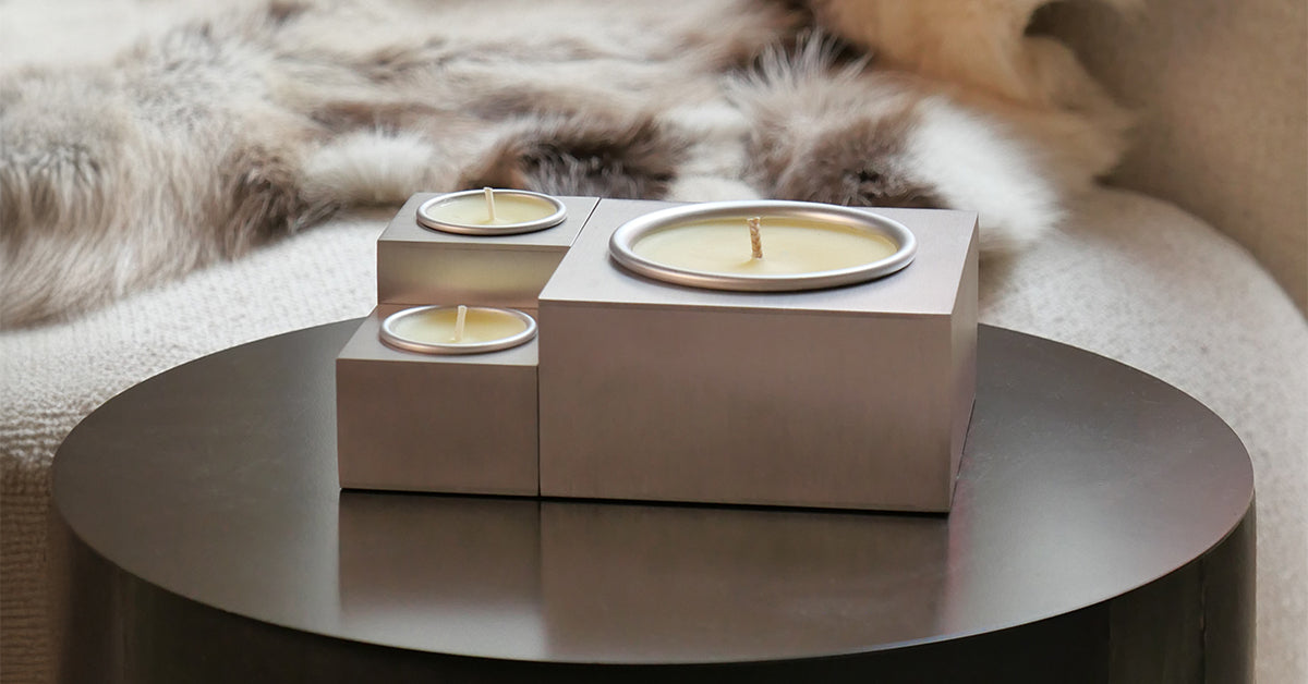 Candele Aura Effusione in alluminio magnetiche su tavolino da salotto in ambiente di design