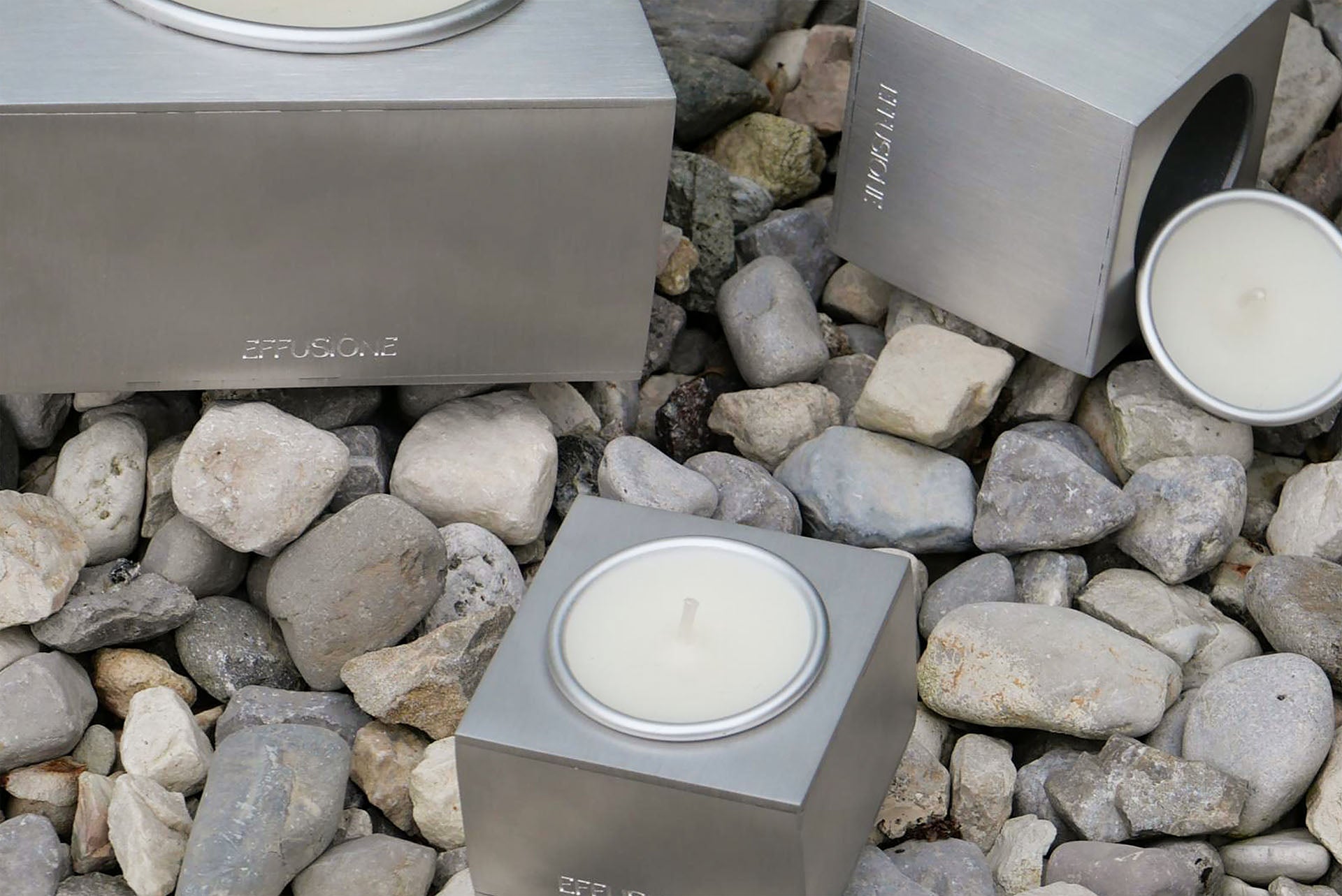 Candele Aura Effusione in alluminio magnetiche posizionate su pietre in ambiente outdoor