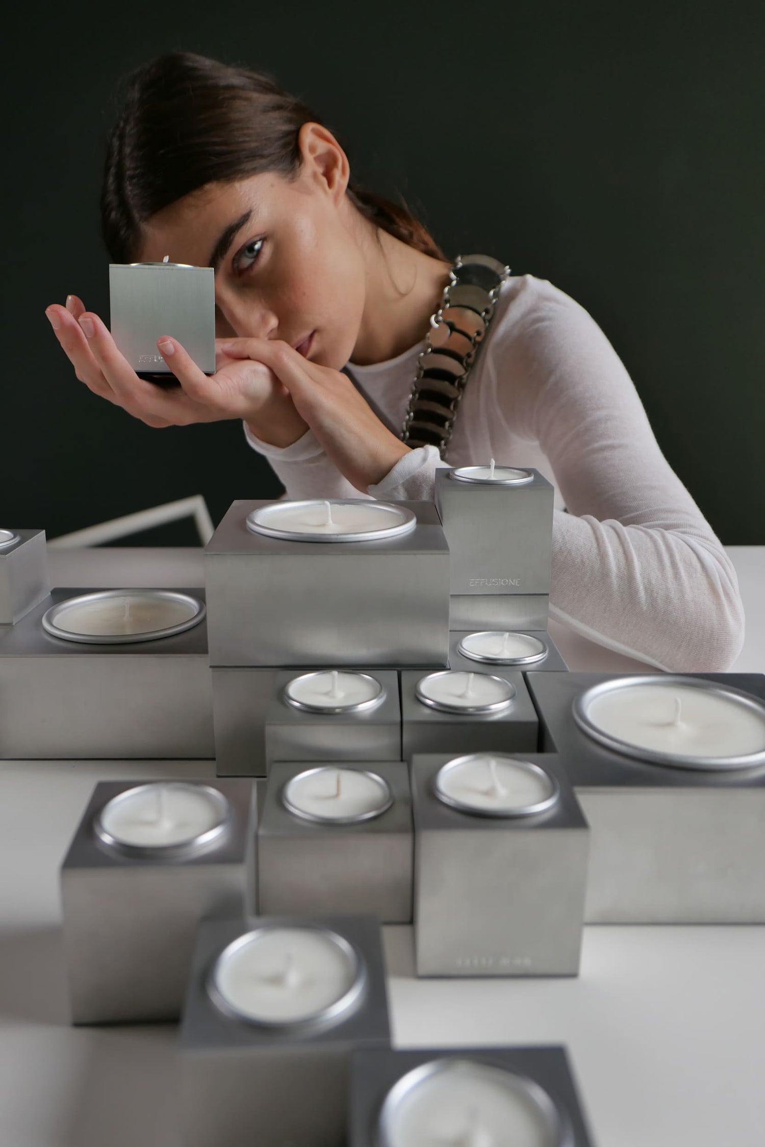 Candele Aura Effusione in alluminio magnetiche componibili di design in foto editoriale con modella